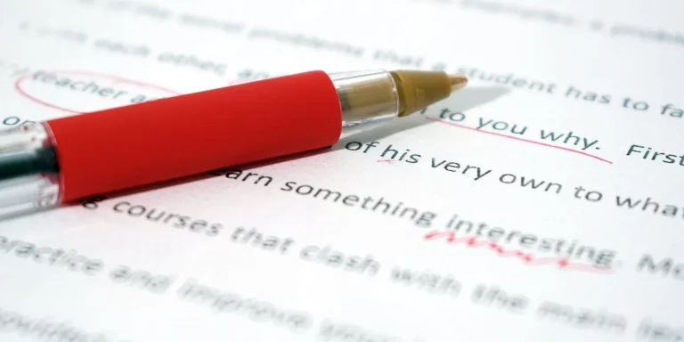 a red pen on a document being grammatically corrected 1