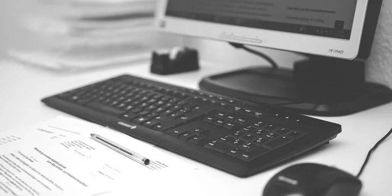 black and white photograph of a monitor keyboard and a mouse