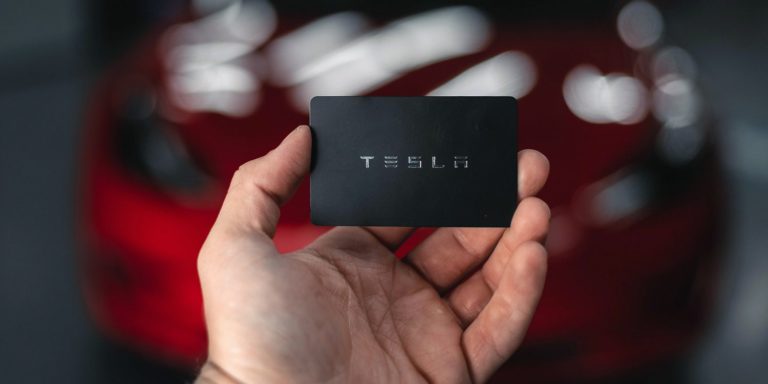 a black Tesla card in front of a red Tesla