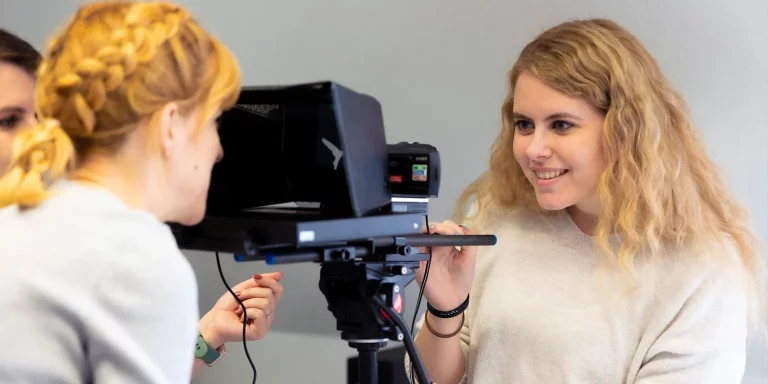 two people working with a teleprompter